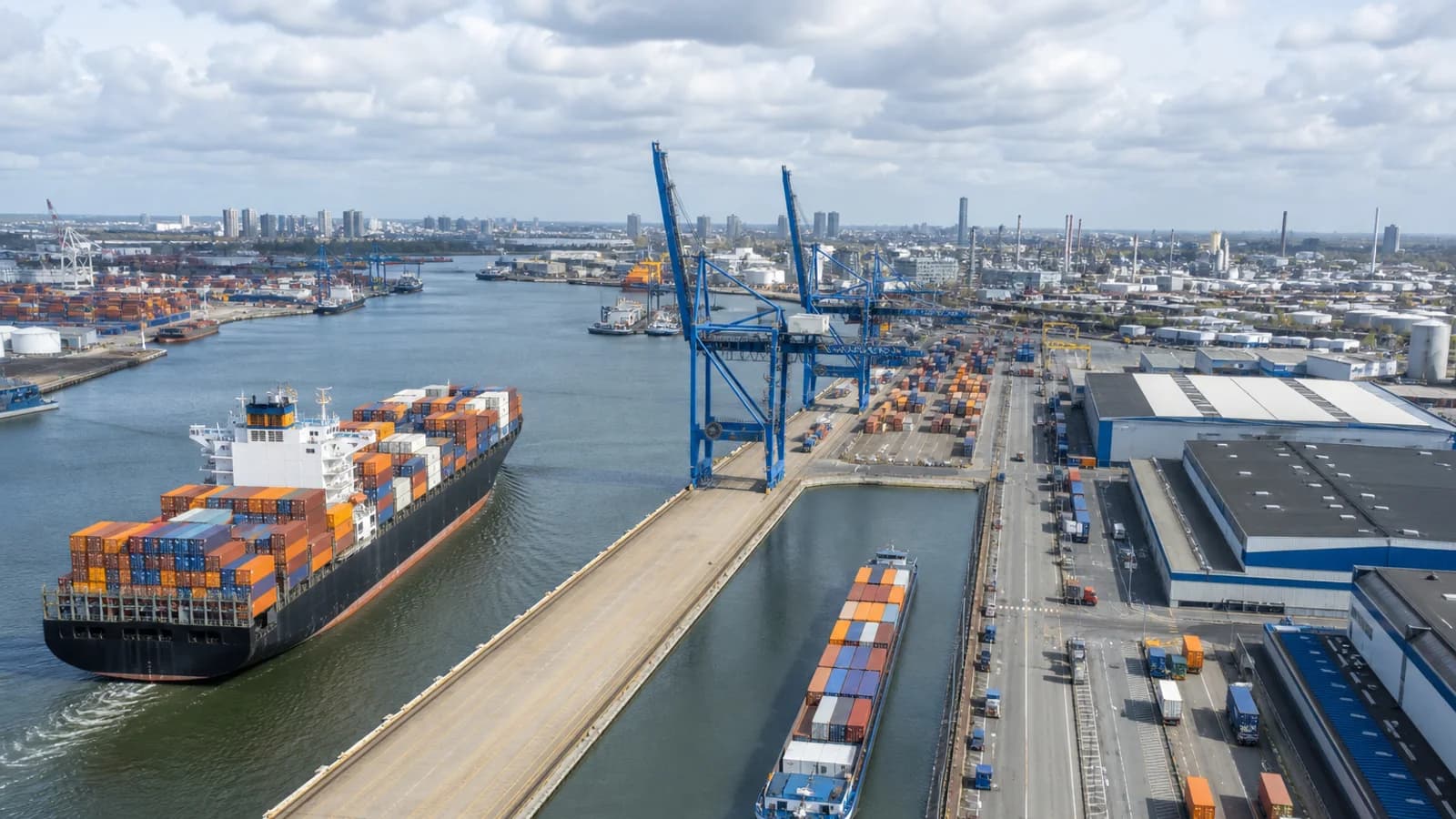 Container freight moving through a modern Rotterdam-style European port terminal.